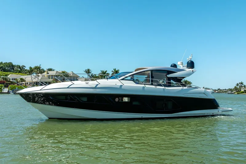 Slide: The Image of 2018 Sunseeker Predator 57 yacht cruising on a sunny day, surrounded by palm trees. - 15