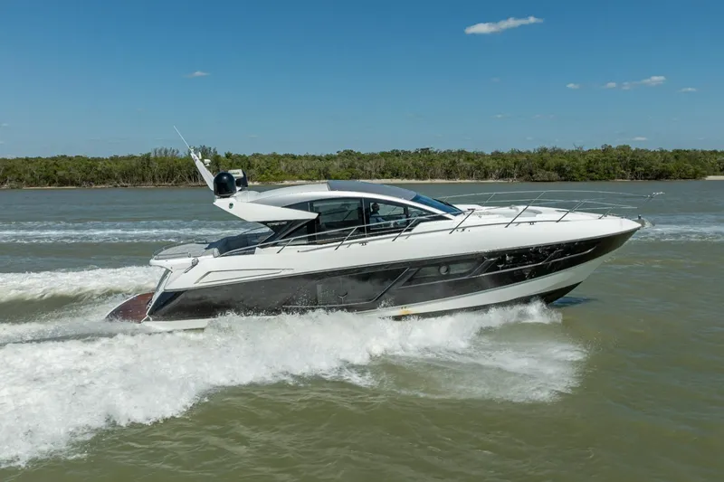 The Image of 2018 Sunseeker Predator 57 yacht cruising on a sunny day, surrounded by water and greenery. - 1