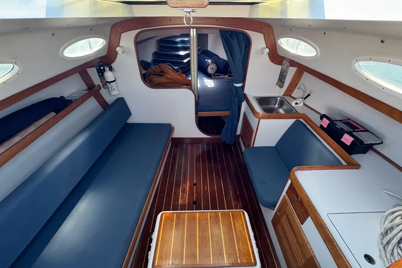 Slide: The Image of Interior of 2000 Alerion Express 28 sailboat with wood accents and blue seating. - 11