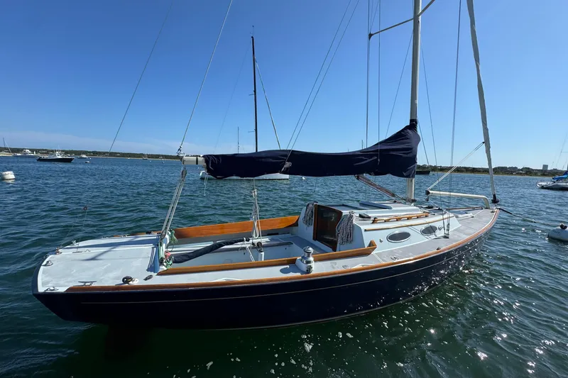 Slide: The Image of Alerion Express 28 sailboat, 2000 model, moored on calm water under clear blue sky. - 2