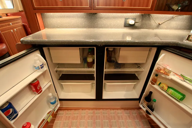 Slide: The Image of Open refrigerator in a 2011 Fathom Element 43 yacht kitchen, stocked with beverages and condiments. - 32