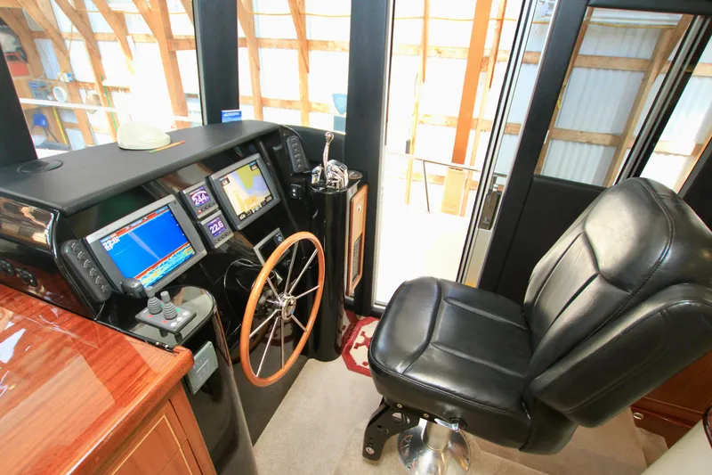 Slide: The Image of Pilot seat and control panel of 2011 Fathom Element 43 boat, featuring navigation screens and steering wheel. - 38