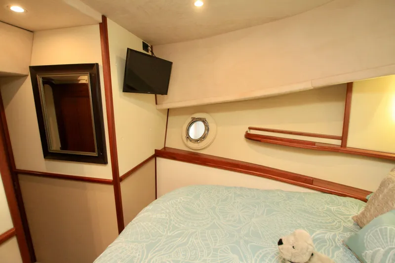 Slide: The Image of Cozy cabin interior of 2011 Fathom Element 43 yacht with bed, TV, and porthole. - 58
