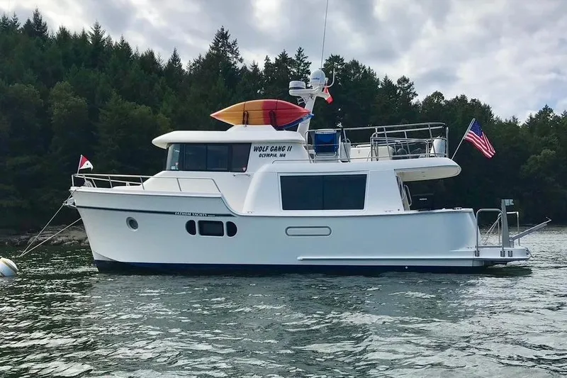 Slide: The Image of 2011 Fathom Element 43 yacht on water, forested background, flags displayed. - 80