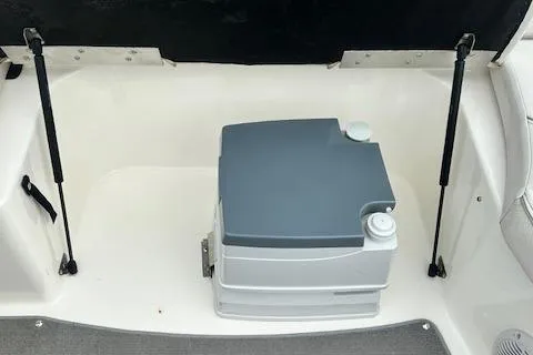 Slide: The Image of 2006 Bayliner 217 Deck Boat interior with portable toilet and storage area. - 19