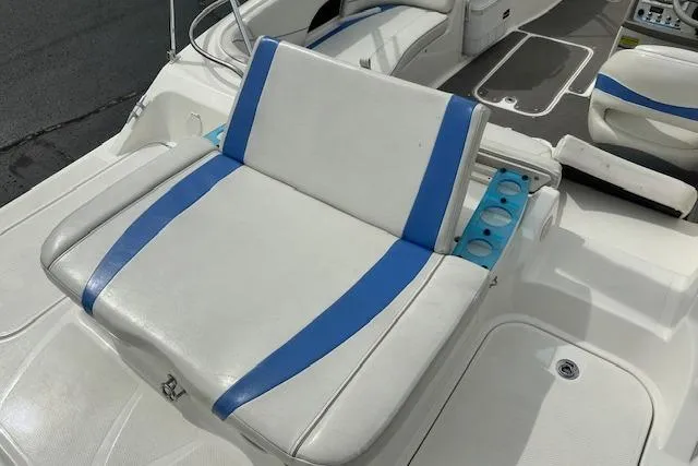 Slide: The Image of 2006 Bayliner 217 Deck Boat seat with blue accents and cup holders. - 7