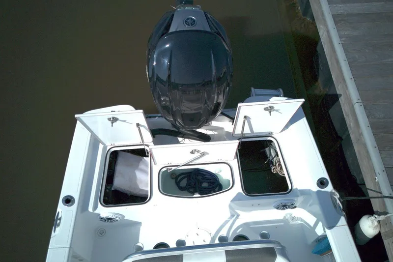 Slide: The Image of Top view of 2024 BlackJack 224 boat with open storage compartments and outboard motor. - 10