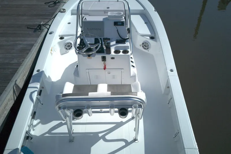 Slide: The Image of 2024 BlackJack 224 boat interior with steering console and seating, docked by wooden pier. - 14