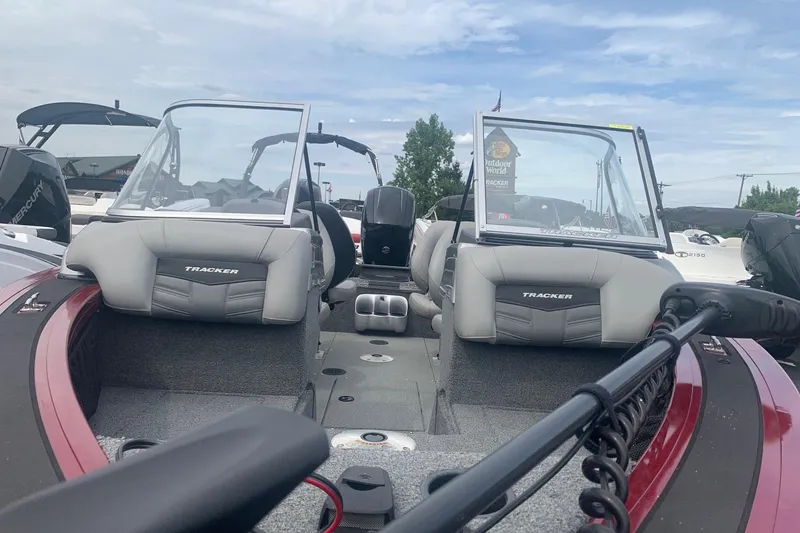 Slide: The Image of 2018 Tracker Targa V-18 Combo boat interior with seating and windshield, under a cloudy sky. - 5
