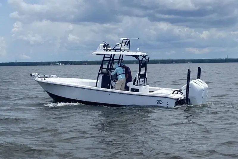 Slide: The Image of 2024 Blazer Bay 2700 Hybrid Bay boat cruising on a calm lake under cloudy skies. - 5