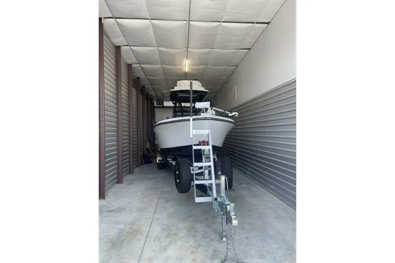 Slide: The Image of 2024 Blazer Bay 2700 Hybrid Bay boat stored in a garage on a trailer. - 7