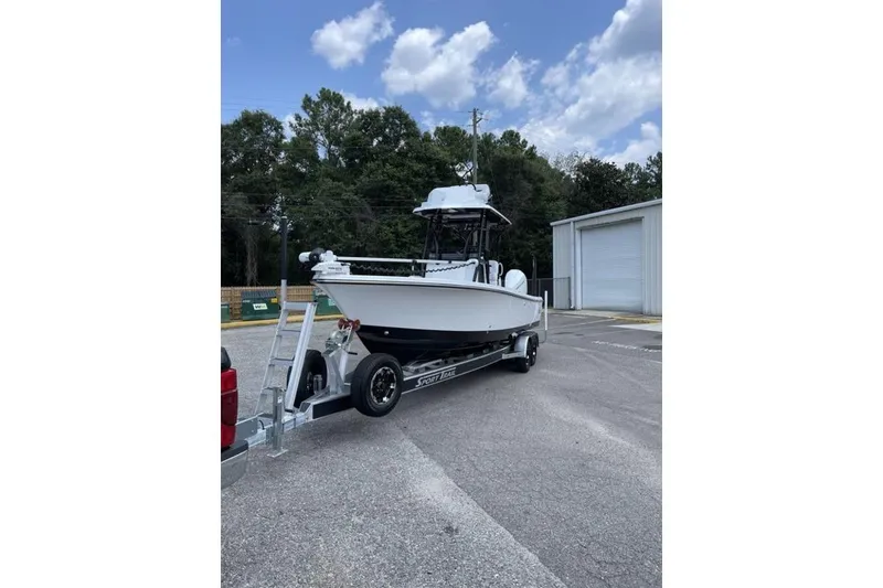 Slide: The Image of 2024 Blazer Bay 2700 Hybrid Bay boat on trailer, parked outdoors. - 8