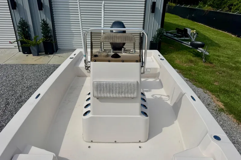 Slide: The Image of 2004 Pathfinder 2200-V boat interior with console and seating, parked outdoors. - 7