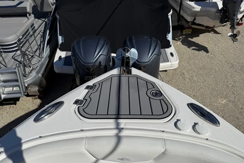 Slide: The Image of 2016 Chaparral 307 SSX boat with dual engines, docked alongside other vessels. - 10