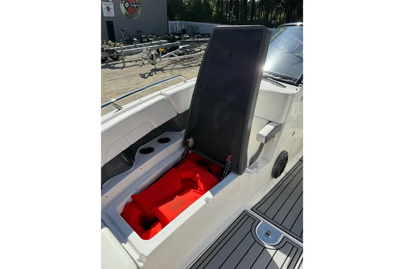 Slide: The Image of 2016 Chaparral 307 SSX boat interior with open storage compartment and red life jackets. - 17