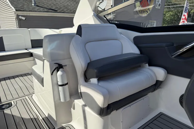 Slide: The Image of 2016 Chaparral 307 SSX boat interior with plush seating and fire extinguisher. - 25