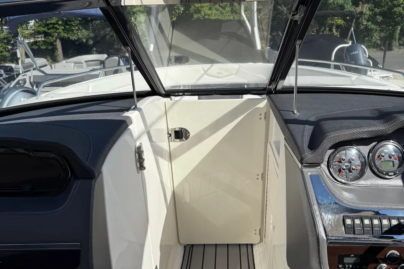 Slide: The Image of 2016 Chaparral 307 SSX boat dashboard with gauges and open cabin door. - 34