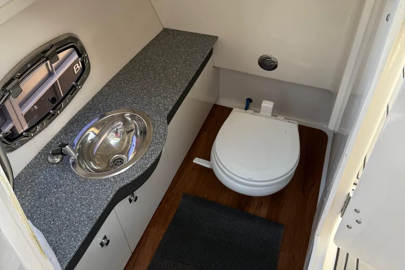 Slide: The Image of 2016 Chaparral 307 SSX boat bathroom with sink, toilet, and wood flooring. - 38