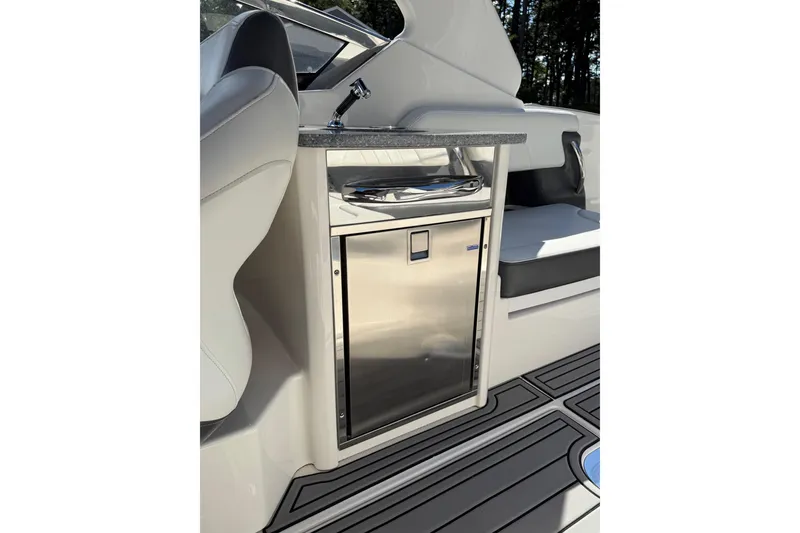Slide: The Image of 2016 Chaparral 307 SSX boat interior with sleek kitchenette and stainless steel fridge. - 42