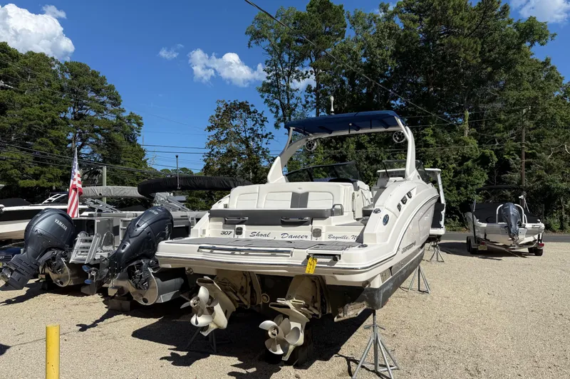 Slide: The Image of 2016 Chaparral 307 SSX boat on display with outboard motors, surrounded by trees. - 5