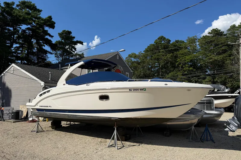 Slide: The Image of 2016 Chaparral 307 SSX boat on stands, parked outdoors under a clear blue sky. - 58