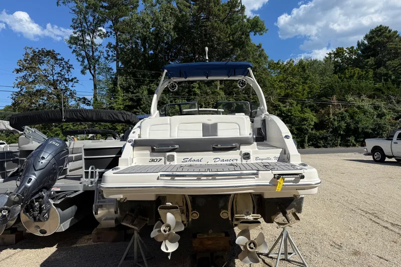 Slide: The Image of 2016 Chaparral 307 SSX boat with dual propellers, parked outdoors on a sunny day. - 6
