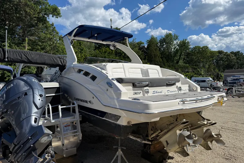 Slide: The Image of 2016 Chaparral 307 SSX boat with Yamaha engine, parked outdoors under a blue sky. - 9