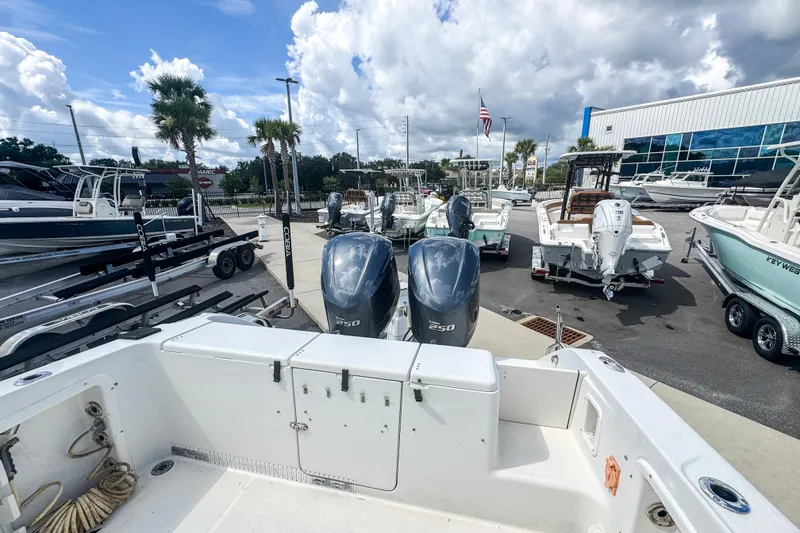 Slide: The Image of 2003 Triton 2895 CC boat with dual 250 engines at a marina under cloudy skies. - 12