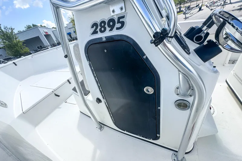 Slide: The Image of 2003 Triton 2895 CC boat console with steering wheel and storage compartment. - 14