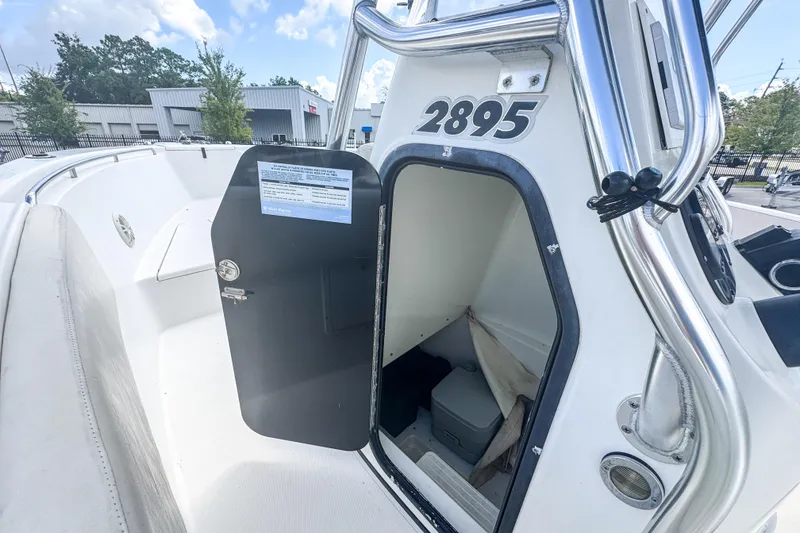 Slide: The Image of 2003 Triton 2895 CC boat interior with open storage compartment and visible seating area. - 15