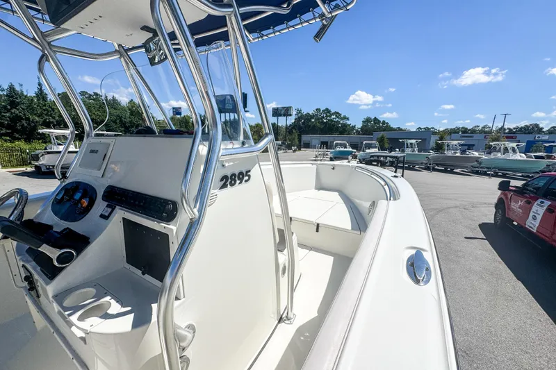 Slide: The Image of 2003 Triton 2895 CC boat with sleek design and modern controls, parked outdoors. - 16