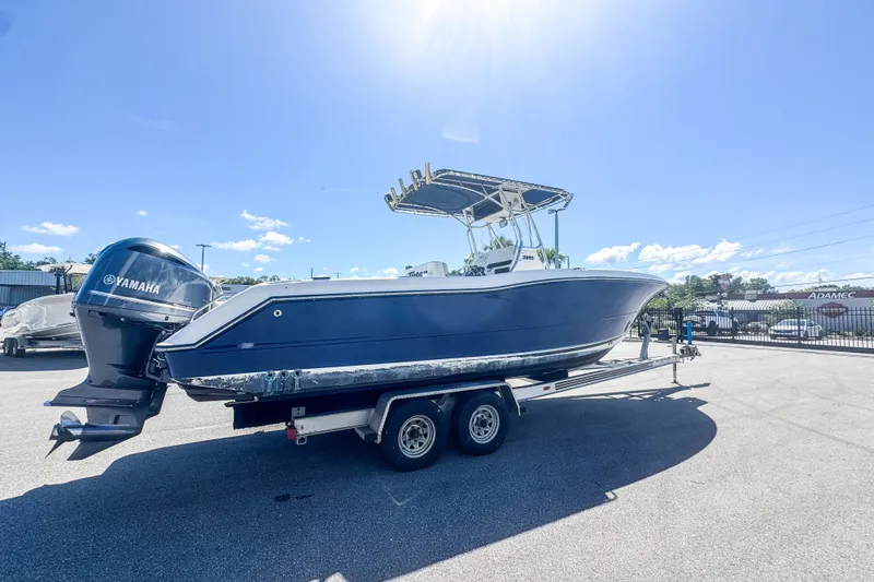 Slide: The Image of 2003 Triton 2895 CC boat on trailer with Yamaha outboard motor under clear blue sky. - 2