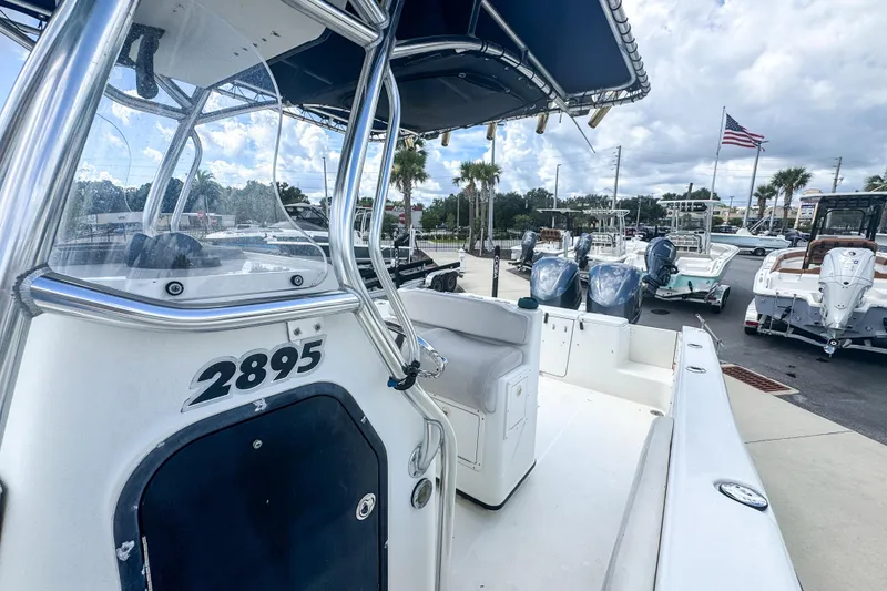 Slide: The Image of 2003 Triton 2895 CC boat displayed at a marina with other vessels. - 9