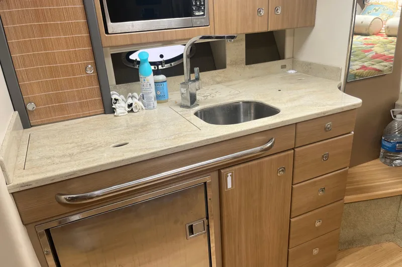 Slide: The Image of 2012 Formula 34 Performance Cruiser kitchen with sink, microwave, and storage cabinets. - 31