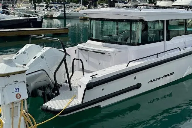 The Image of 2024 Axopar 37 XC Cross Cabin Wet Bar docked in a marina, showcasing sleek design. - 0
