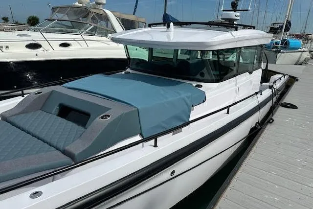 Slide: The Image of 2024 Axopar 37 XC Cross Cabin Wet Bar docked, featuring sleek design and spacious deck. - 11