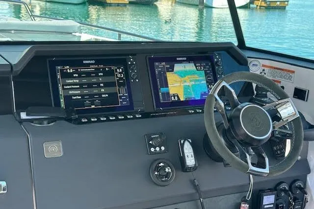 Slide: The Image of 2024 Axopar 37 XC Cross Cabin helm with dual Simrad displays and modern steering wheel. - 15