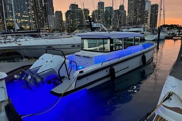 Slide: The Image of 2024 Axopar 37 XC Cross Cabin Wet Bar illuminated at marina during sunset. - 17