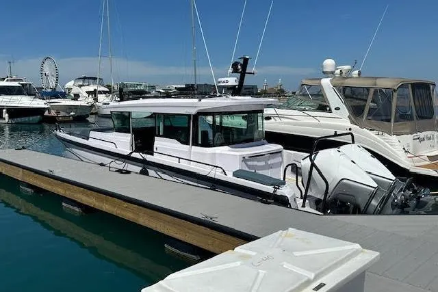 Slide: The Image of 2024 Axopar 37 XC Cross Cabin Wet Bar docked at marina, clear sky background. - 6