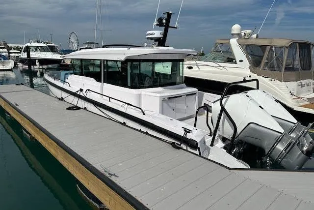 Slide: The Image of 2024 Axopar 37 XC Cross Cabin Wet Bar docked at marina, showcasing sleek design. - 7