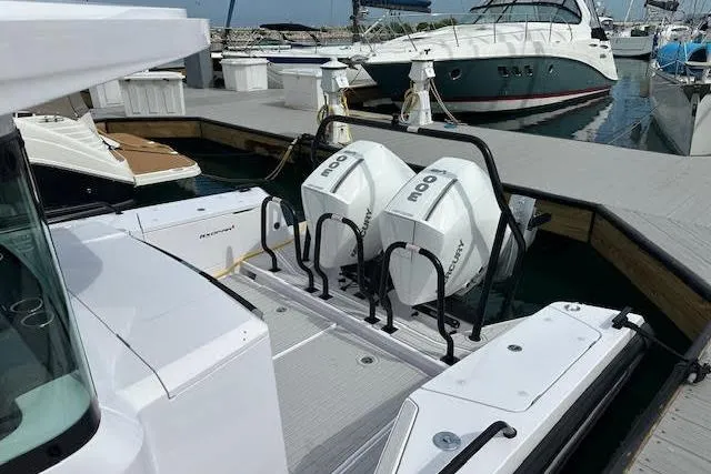 Slide: The Image of 2024 Axopar 37 XC Cross Cabin Wet Bar with dual outboard engines docked at marina. - 8