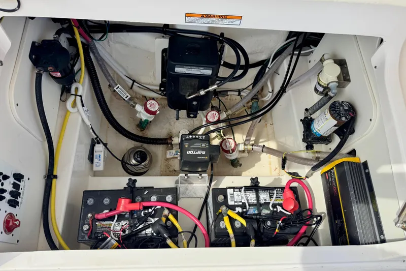 Slide: The Image of 2022 Robalo 266 Cayman boat engine compartment with wiring and battery setup. - 11