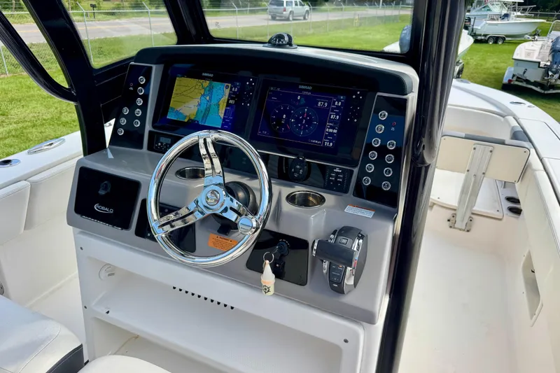 Slide: The Image of 2022 Robalo 266 Cayman boat dashboard with navigation screens and steering wheel. - 15