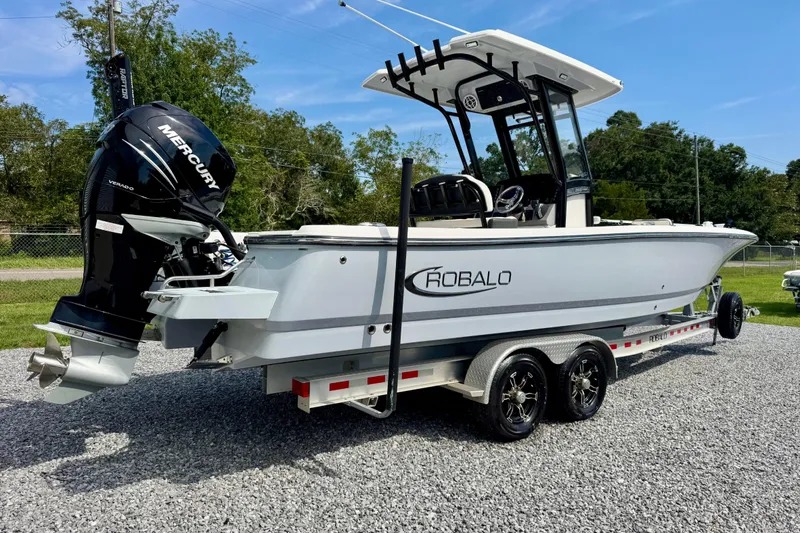 Slide: The Image of 2022 Robalo 266 Cayman boat on trailer with Mercury engine, parked outdoors. - 3