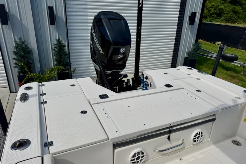 Slide: The Image of 2022 Robalo 266 Cayman boat with Mercury outboard motor, docked near a metal building. - 9