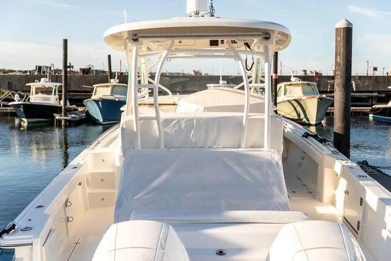 Slide: The Image of 2024 Hinckley Sport Boat 40c, luxurious seating, docked on calm waters. - 11