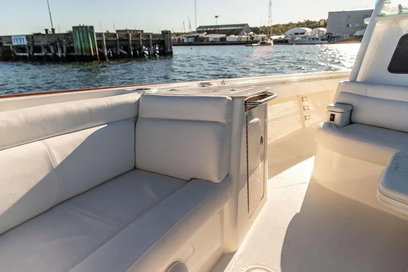 Slide: The Image of 2024 Hinckley Sport Boat 40c with American flag, white seating, and dual engines on water. - 25