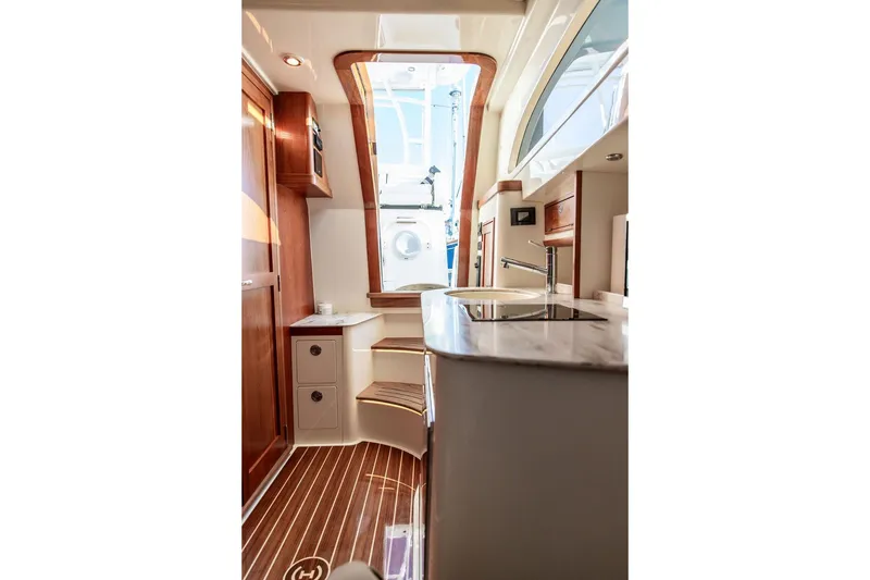 Slide: The Image of 2024 Hinckley Sport Boat 40c interior with white seating, dockside view. - 27