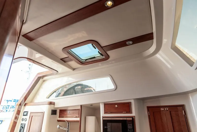 Slide: The Image of Interior view of 2024 Hinckley Sport Boat 40c cabin with window and seating. - 32