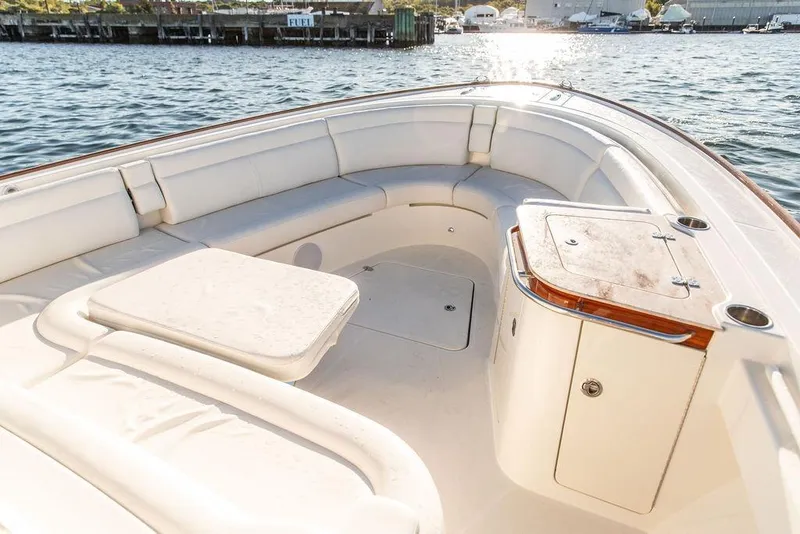 Slide: The Image of 2024 Hinckley Sport Boat 40c cruising on a serene lake with forested shoreline. - 4